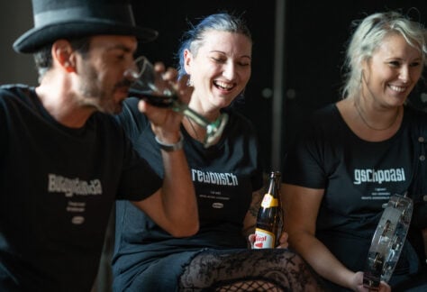 Ein Mann und zwei Frauen machen Party und tragen dabei OstSeele-Shirts.