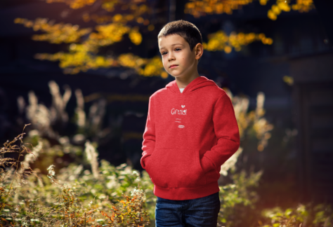 Bub mit OstSeele-Hoodie steht in der Natur.