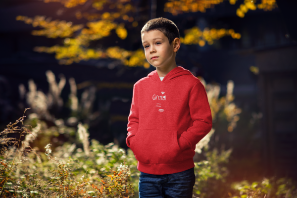 Bub mit OstSeele-Hoodie steht in der Natur.