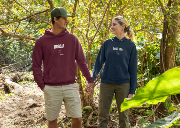 Eine Frau und ein Mann in OstSeele-Hoodies spazieren durch den Wald.